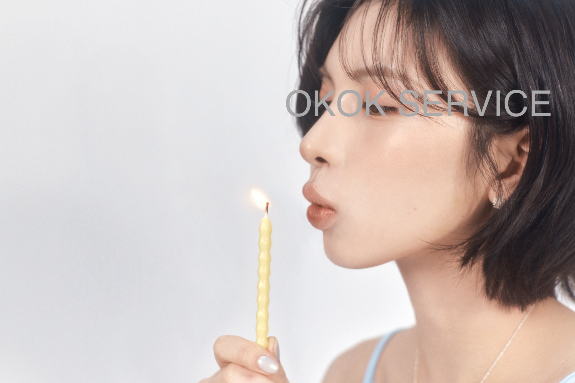 Leaning in to blow out a single lit candle